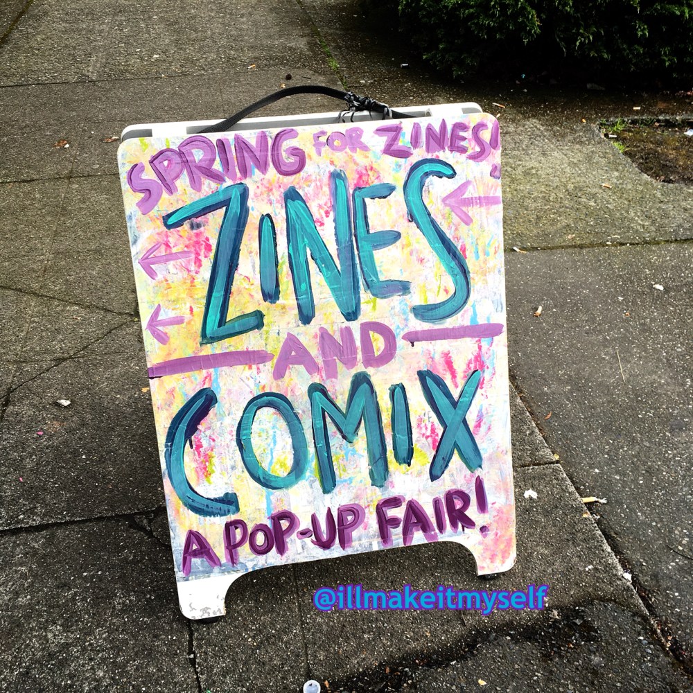 Image of a sandwich board with the text Spring for Zines! Zines and Comix: A Pop-Up Fair!