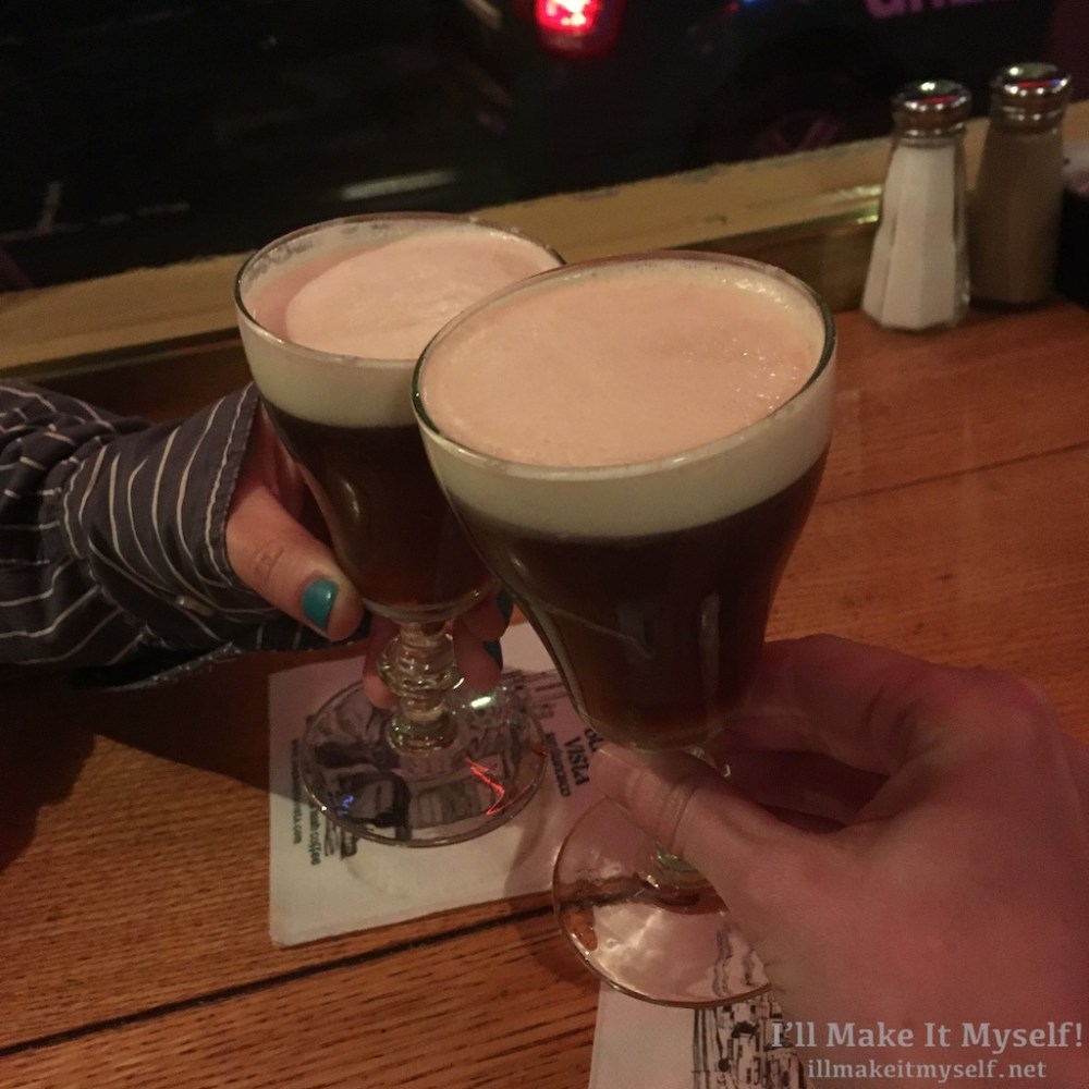 close up of Robin's and my hands toasting with our Irish Coffee.