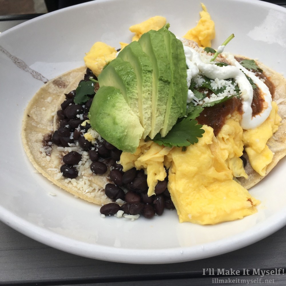 Huevos rancheros with sala roja, eggs, beans, cilantro, and queso fresco