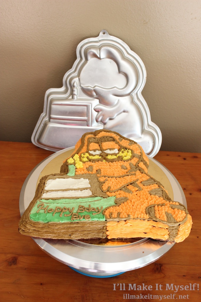 Image of the finished cake with its pan. The pan shows the outline of Garfield with the cake but has a flat blank spot where the eye piece would go.