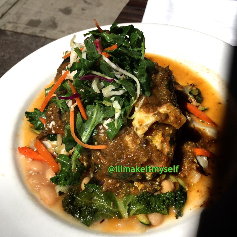 A poblano stuffed with quinoa, sweet potato, and apples, topped with queso fresco and salsa, and served with garbanzos and veggies. Close up. the far right side is in shadow.