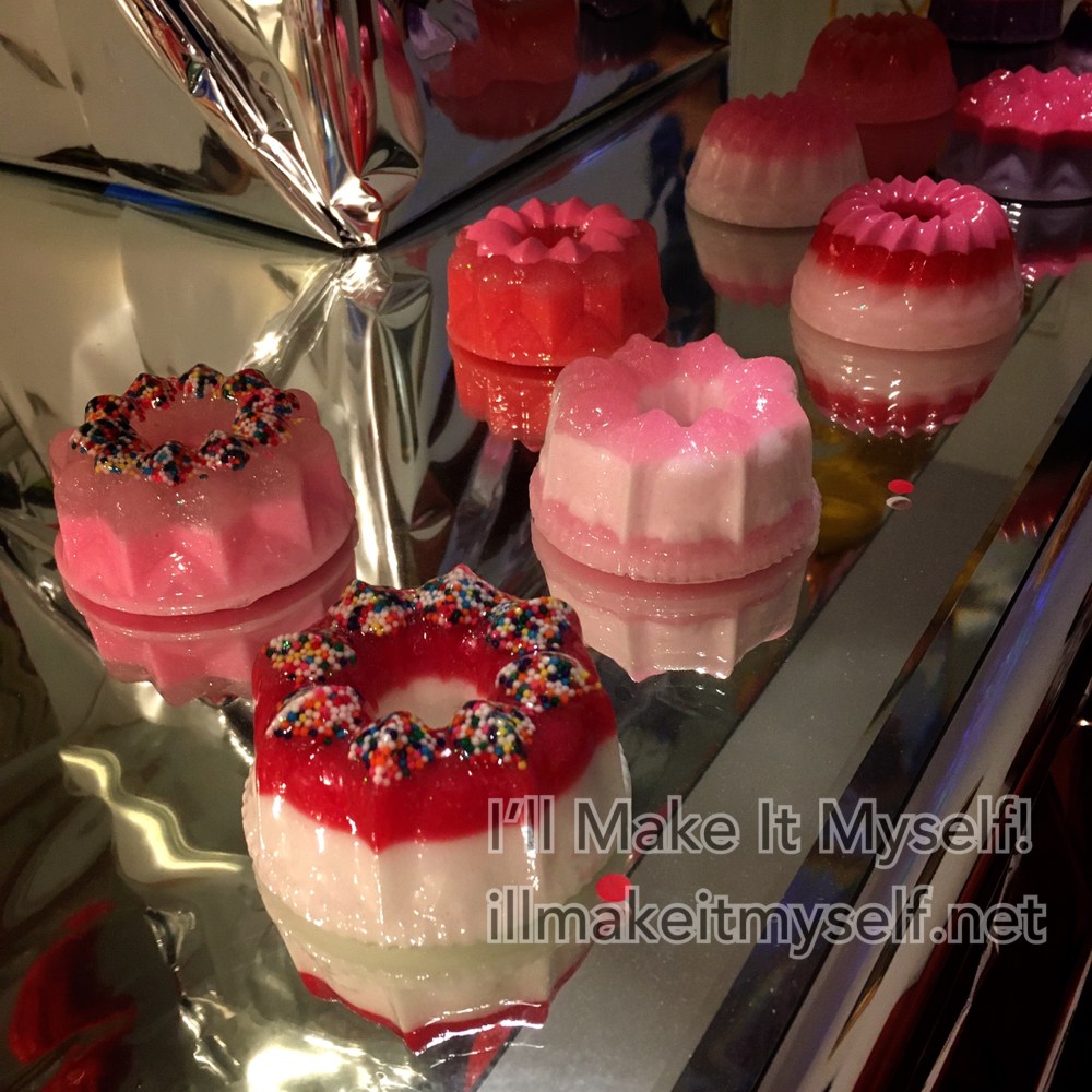 Photo of 7 small resin molds shaped like pink Jello molds with sprinkles and gradations in pink and white